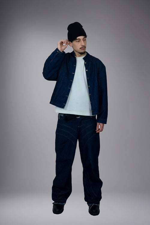 Full-body front view of a dark raw denim jacket worn open with matching wide baggy jeans and contrast stitching. - Motor Cycle Brut