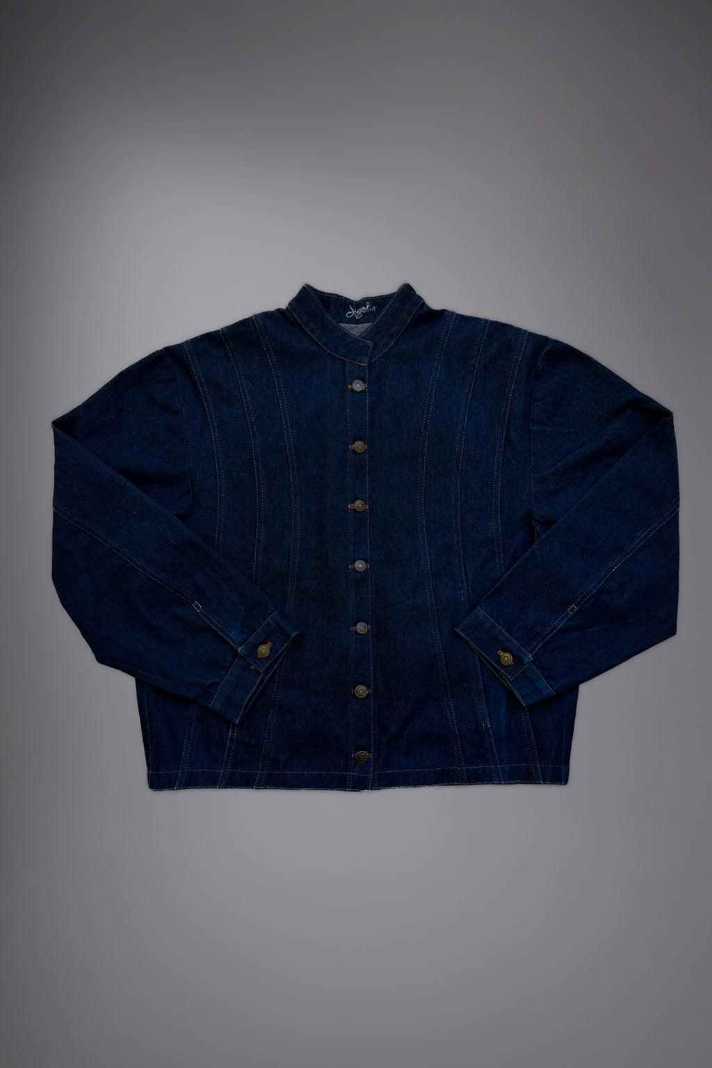 lat lay of a dark raw denim jacket with metal button closure, structured collar, contrast stitching and wide sleeves. - Motor Cycle Brut