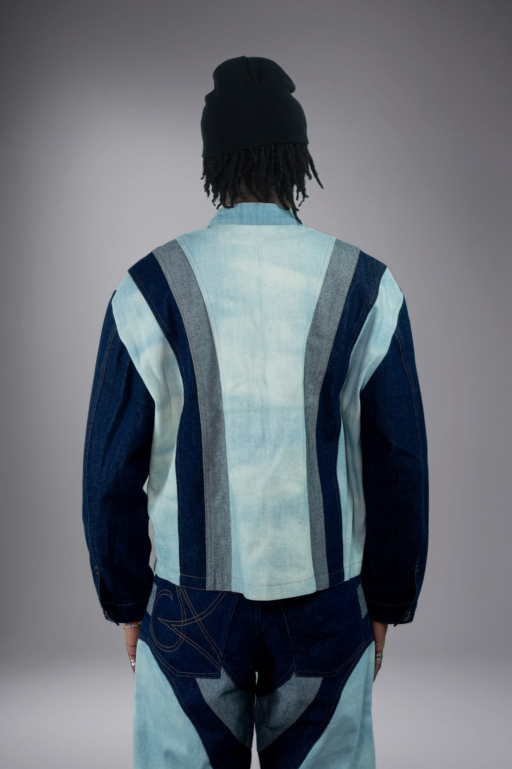 Back view of a two-tone denim jacket with light wash center panel, dark denim sleeves, grey side panels and matching wide-leg jeans. - Motor Cycle Triple Jean