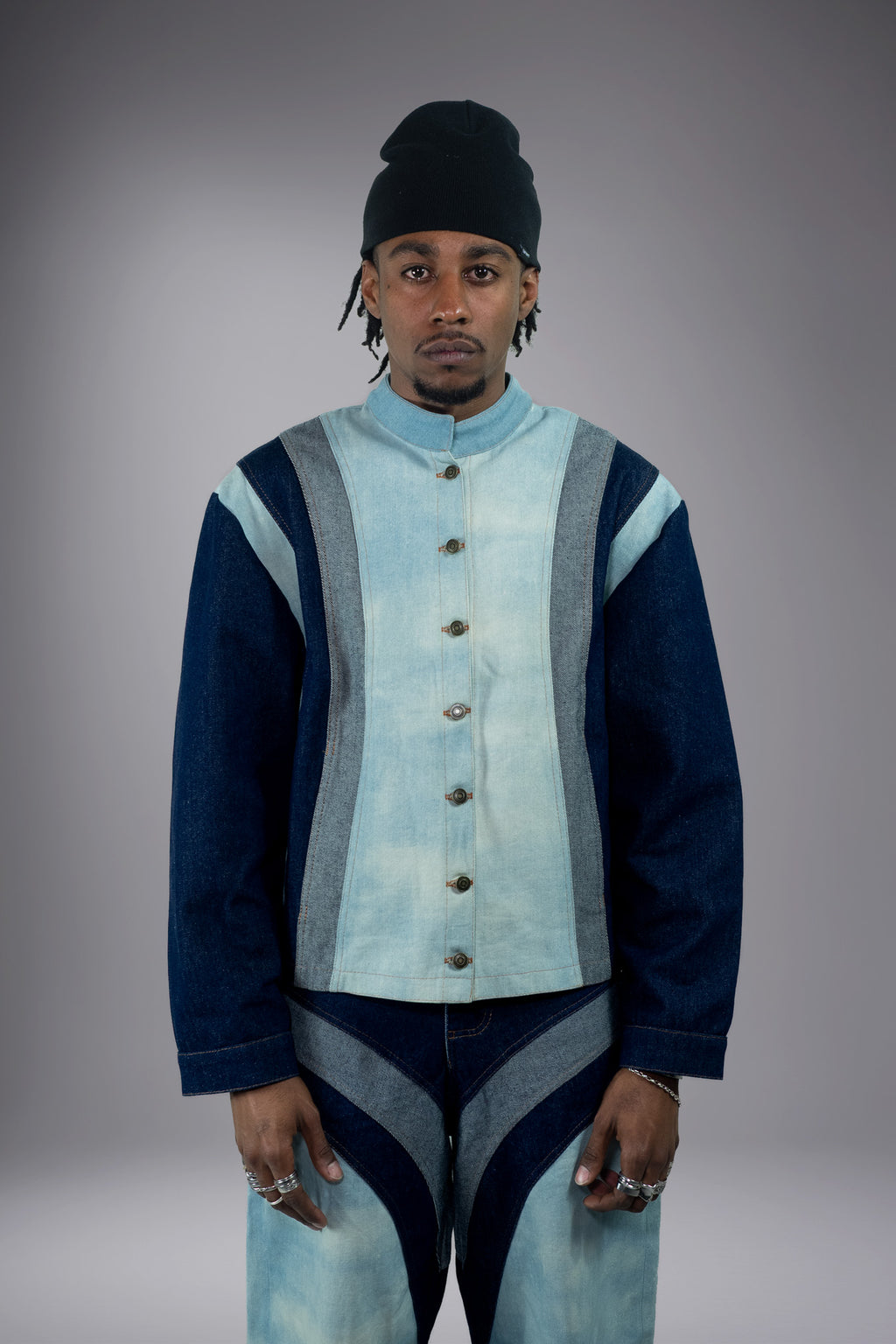 Front view of a two-tone denim jacket with light wash body, dark denim sleeves, grey side panels, metal buttons and matching wide-leg jeans. - Motor Cycle Triple Jean