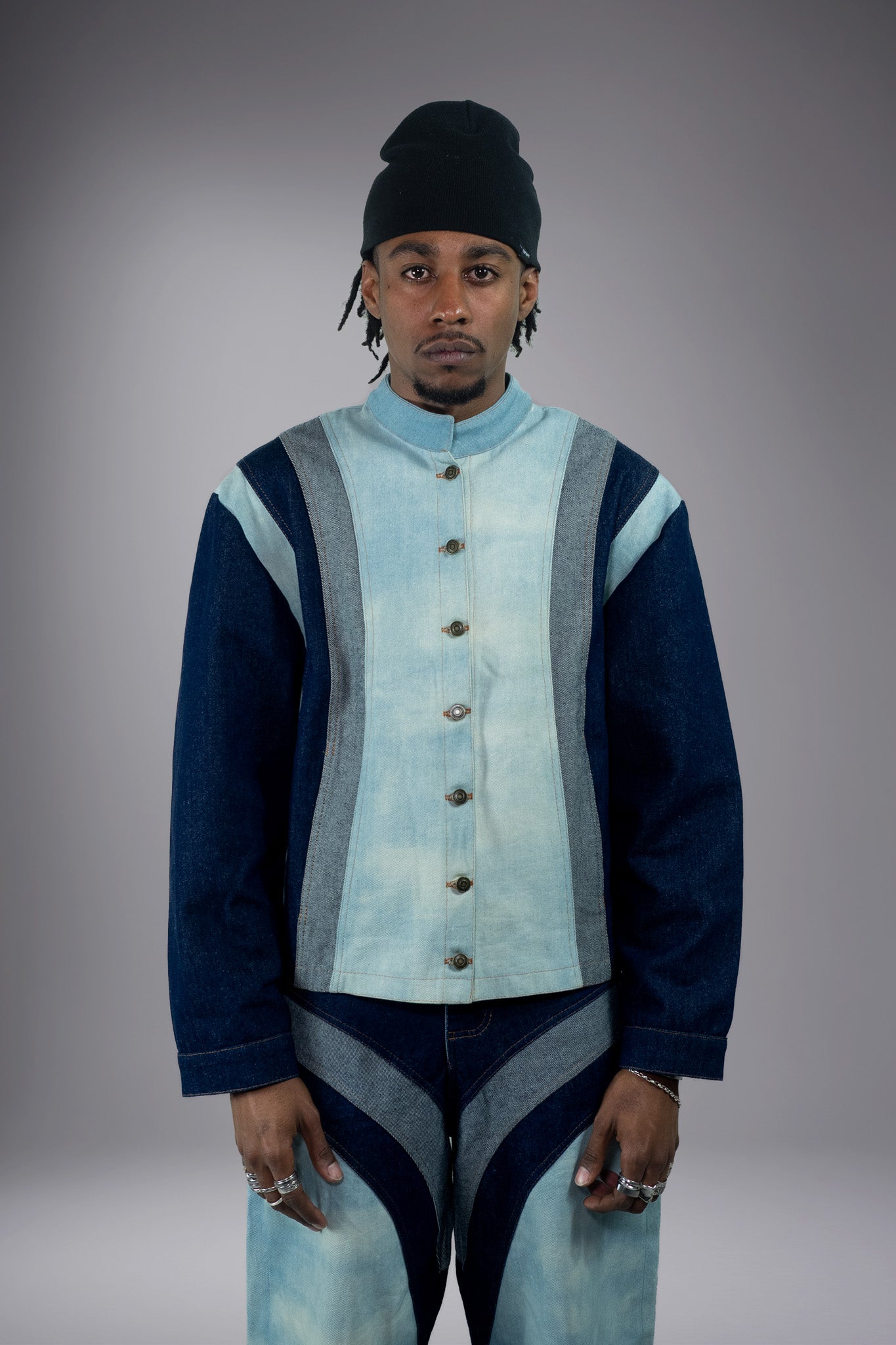 Front view of a two-tone denim jacket with light wash body, dark denim sleeves, grey side panels, metal buttons and matching wide-leg jeans. - Motor Cycle Triple Jean