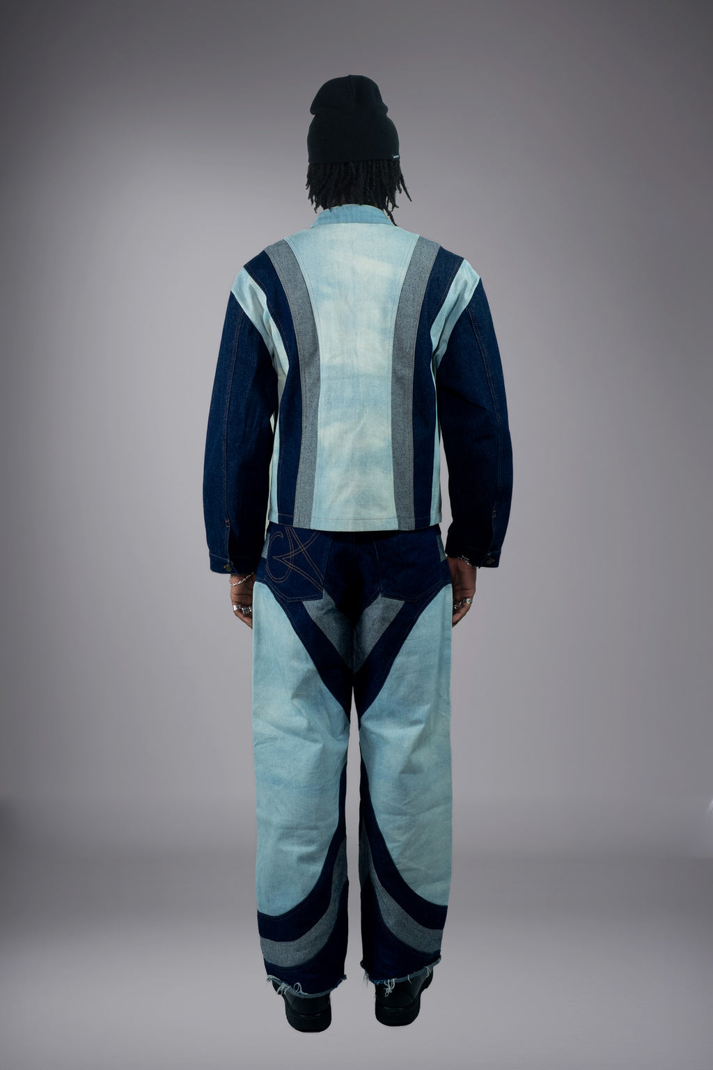 Full-body back view of a two-tone denim jacket and matching wide-leg jeans with dark curved inserts and raw hem details. - Motor Cycle Triple Jean