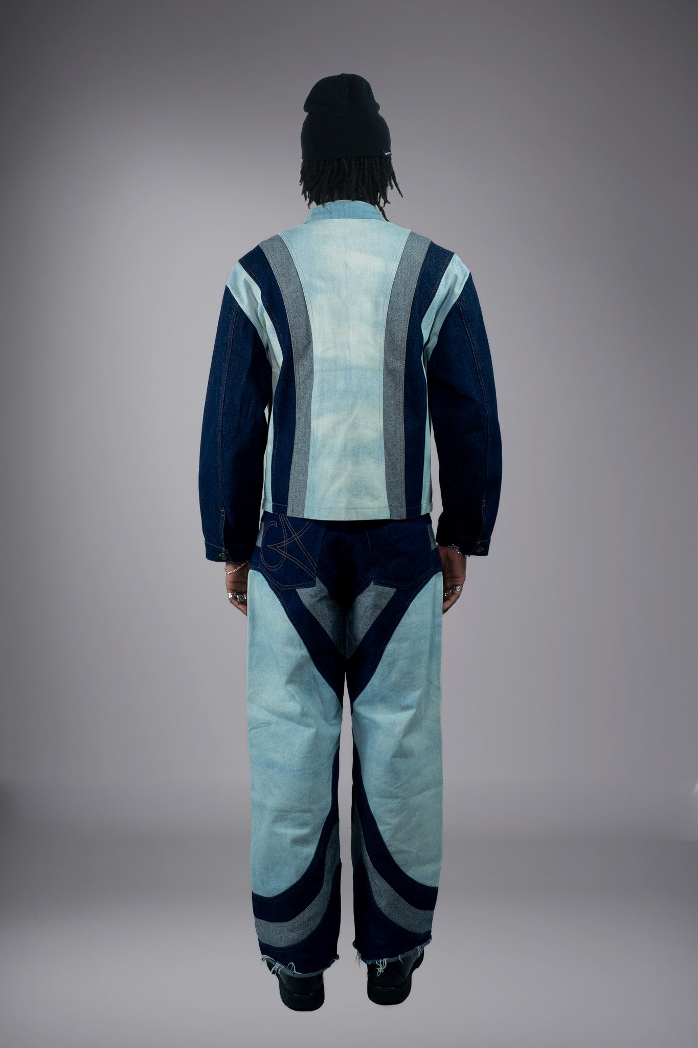 Full-body back view of a two-tone denim jacket and matching wide-leg jeans with dark curved inserts and raw hem details. - Motor Cycle Triple Jean