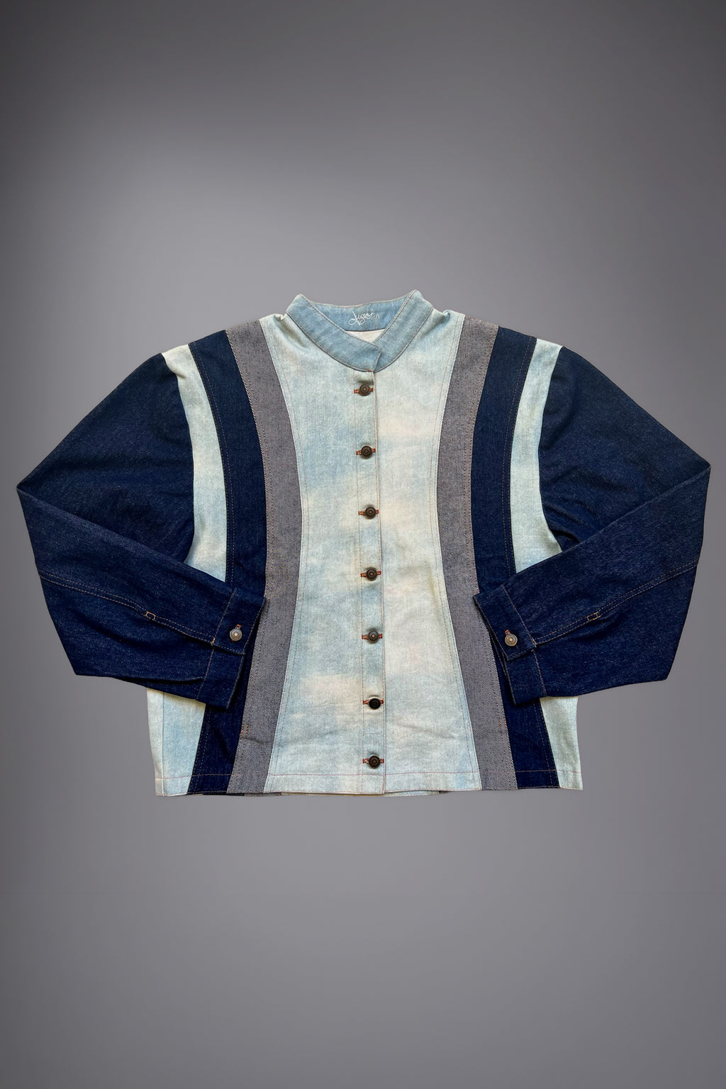 lat lay of a two-tone denim jacket with light wash body panels, dark denim sleeves, grey side inserts, metal buttons and contrast stitching. - Motor Cycle Triple Jean