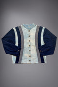 lat lay of a two-tone denim jacket with light wash body panels, dark denim sleeves, grey side inserts, metal buttons and contrast stitching. - Motor Cycle Triple Jean