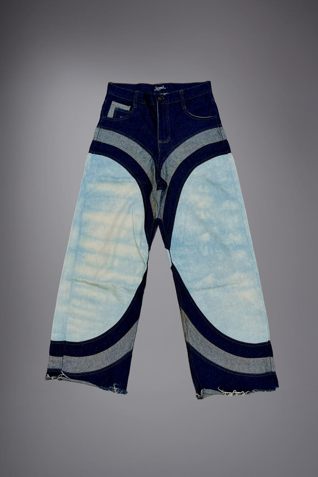 Flat lay of two-tone wide-leg denim jeans with light wash panels, dark curved inserts, contrast stitching and raw hem details. - Motor Cycle Triple Jean