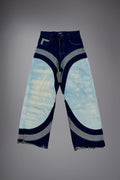 Flat lay of two-tone wide-leg denim jeans with light wash panels, dark curved inserts, contrast stitching and raw hem details. - Motor Cycle Triple Jean